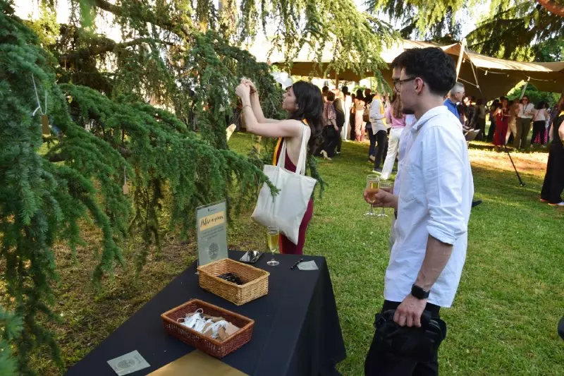 Étudiante accrochant un mot sur l'Arbre à Souhaits de la Cérémonie de remise de diplômes