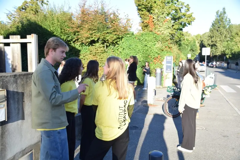 Des étudiants bénévoles en t-shirts jaunes guident de nouveaux élèves devant l'entrée du campus pour préparer sa rentrée à l'Institut Limayrac.