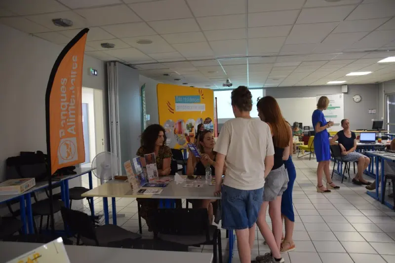 Des jeunes échangent avec des intervenantes au stand des Banques Alimentaires pour découvrir les aides aux étudiants à Toulouse lors du forum de pré-rentrée.