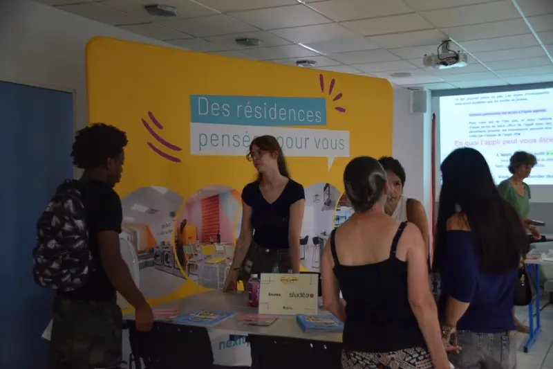 Des étudiants se renseignent sur les logements et les aides aux étudiants de Toulouse devant le stand des résidences Nexity Studéa.