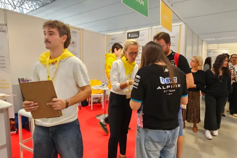 Personnes donnant des conseils aux visiteurs d'un stand au salon d'orientation